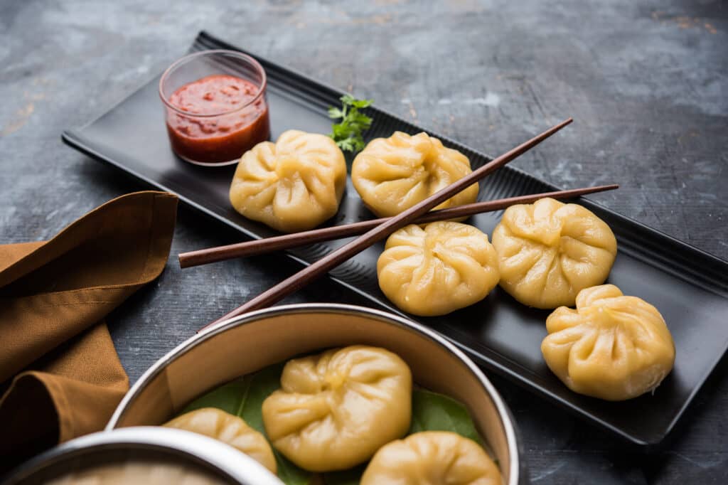 Traditional dumpling momos food served with tomato chutney